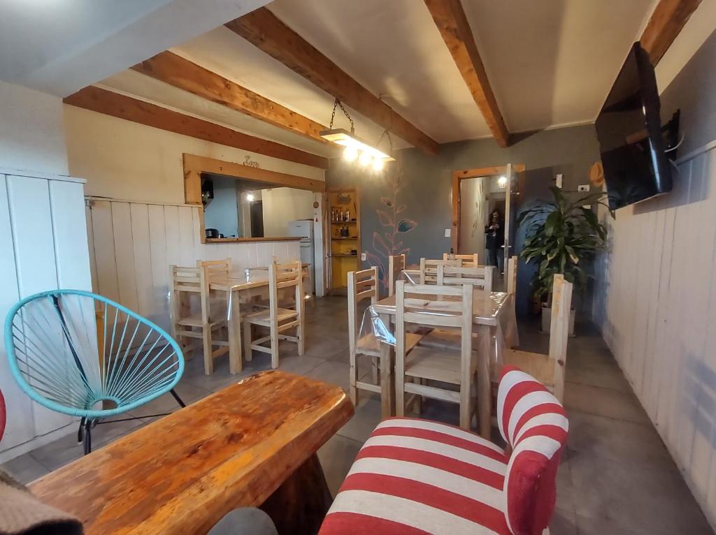 Temiscira Hostel في سان كارلوس دي باريلوتشي: غرفة طعام بها طاولات وكراسي وتلفزيون