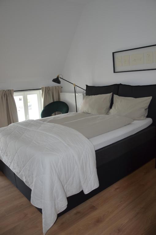 a large bed with a white blanket on top of it at Wersauer Hof - Ferme Auberge in Reilingen