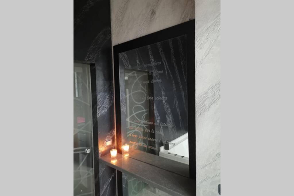 Camera relax Fuorigrotta في نابولي: مرآة على جدار مع شمعة فيه