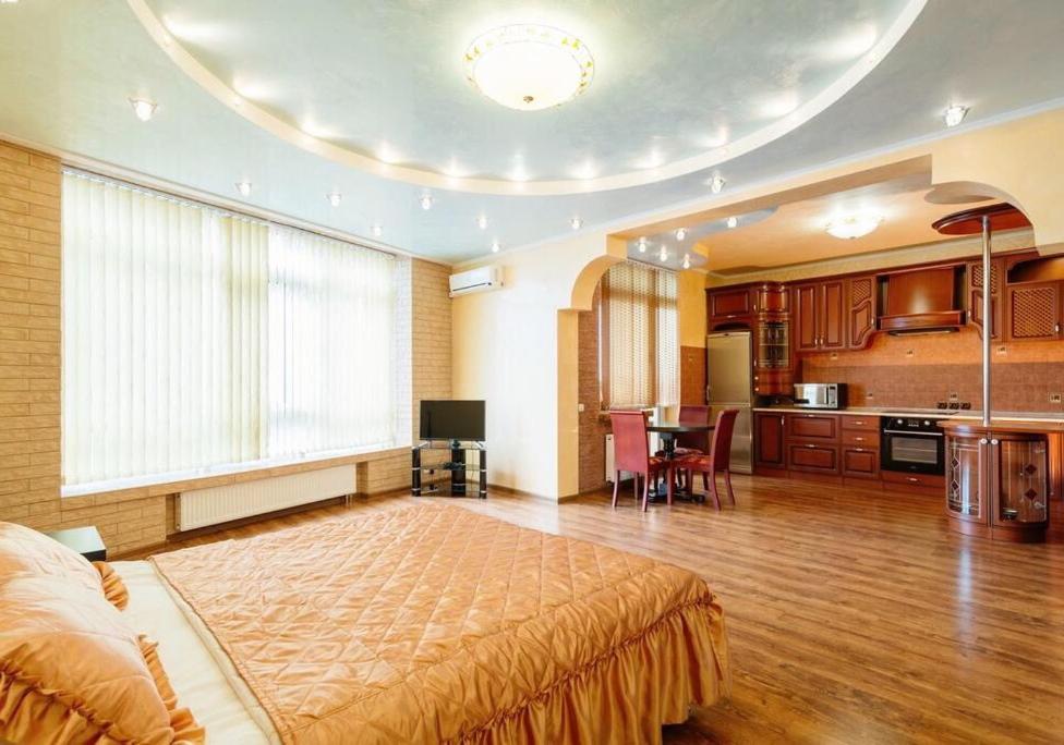 ein großes Schlafzimmer mit einem großen Bett und einer Küche in der Unterkunft VIP апартаменти з видом на озеро in Kiew