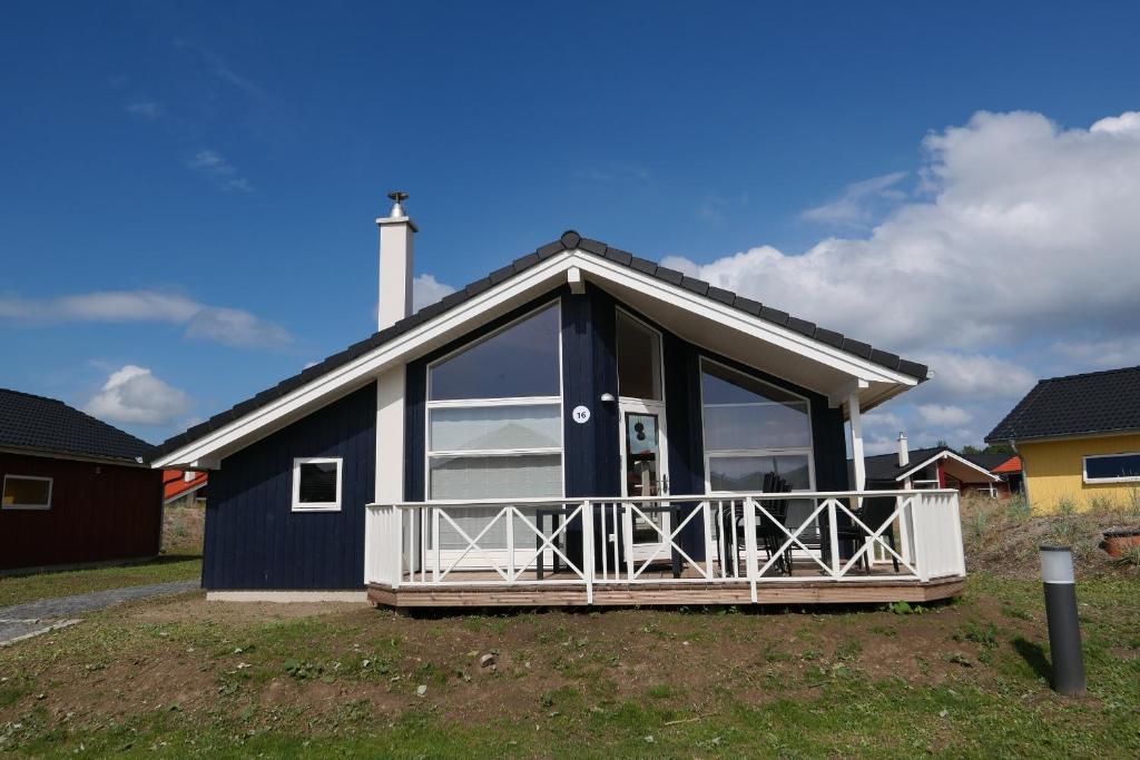 een blauw huis met een veranda en een balkon bij Resort 2 Ocean Cottage A 16 in Großenbrode