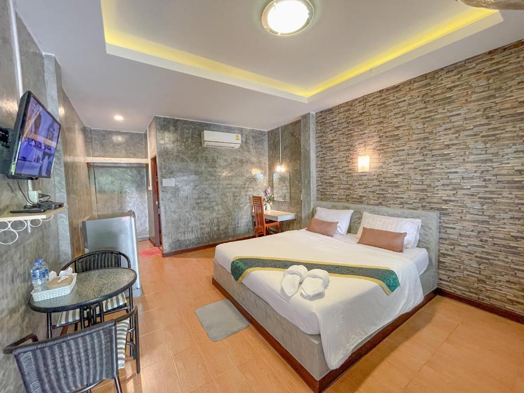 una camera con letto king-size e parete in mattoni di โรงแรมโทนี่วิลเลจTony Hotel a Phatthalung