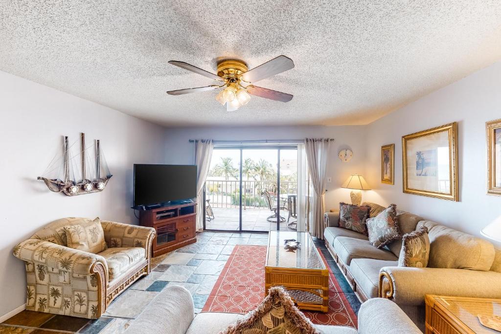 a living room with a couch and a ceiling fan at Reef Club 304 in Clearwater Beach