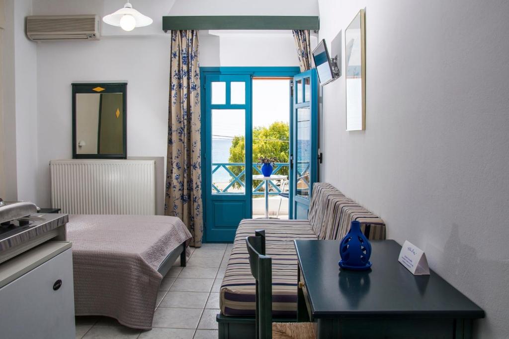 a hotel room with a bed and a table and a room at Villa Irida in Psari Forada