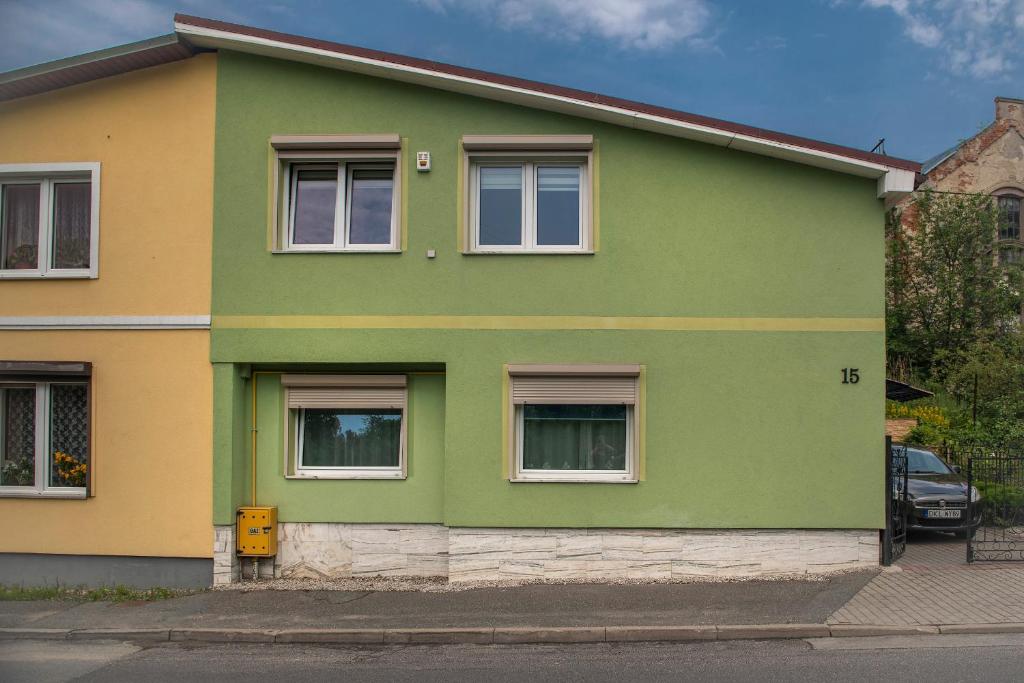 隆代克－茲德魯伊的住宿－Apartament LUIZA，街上的绿色和黄色房子