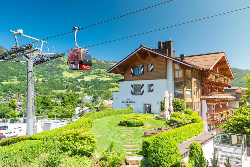 ein Haus auf einem Hügel mit einer Seilbahn in der Unterkunft Hotel Kaiserhof Kitzbühel, 4 Sterne Superior in Kitzbühel