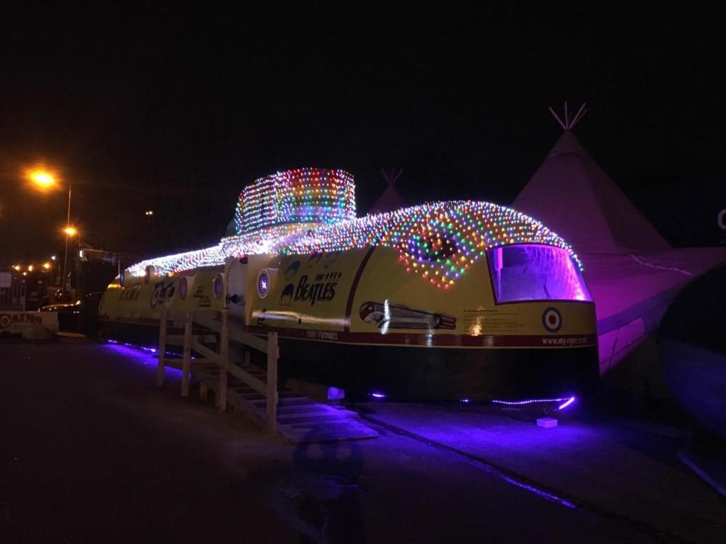 a train covered in christmas lights on a boat at The WOODEN LODGE NO 1 AT THE BALTIC CAINS BREWERY in Liverpool