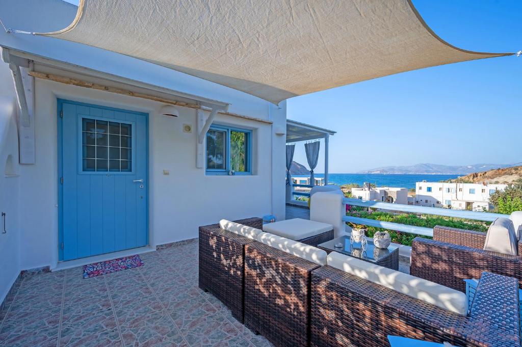 a patio with a blue door and a view of the ocean at Molos Sea View House - Paros Greece in Molos Parou