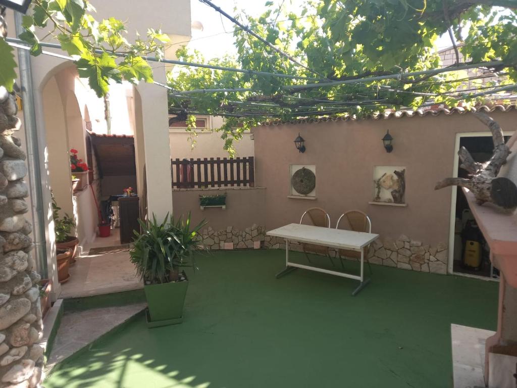 a patio with a table and a bench in a courtyard at Apartmani Robert in Bol