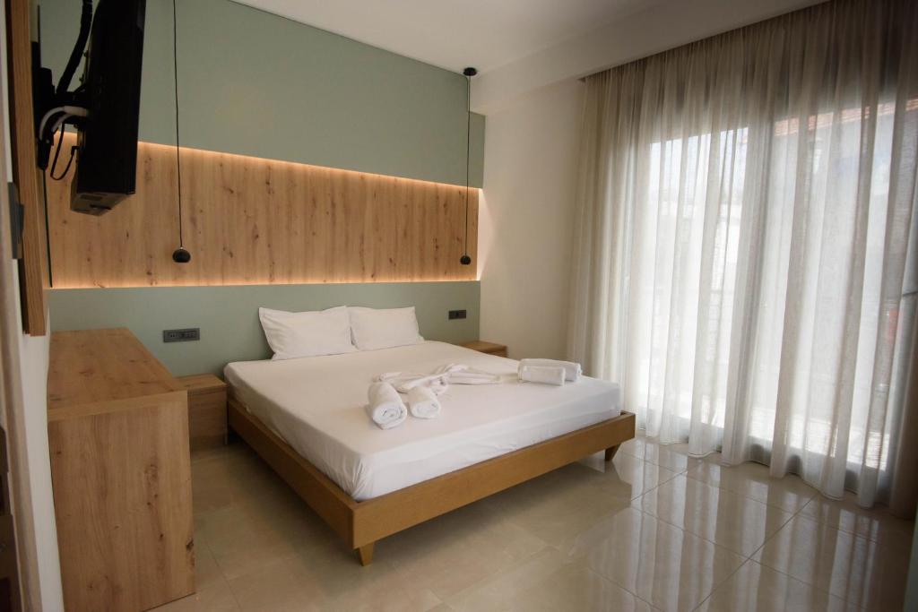 - une chambre avec un lit et des serviettes dans l'établissement Villa Ikaros, à Ammoudia