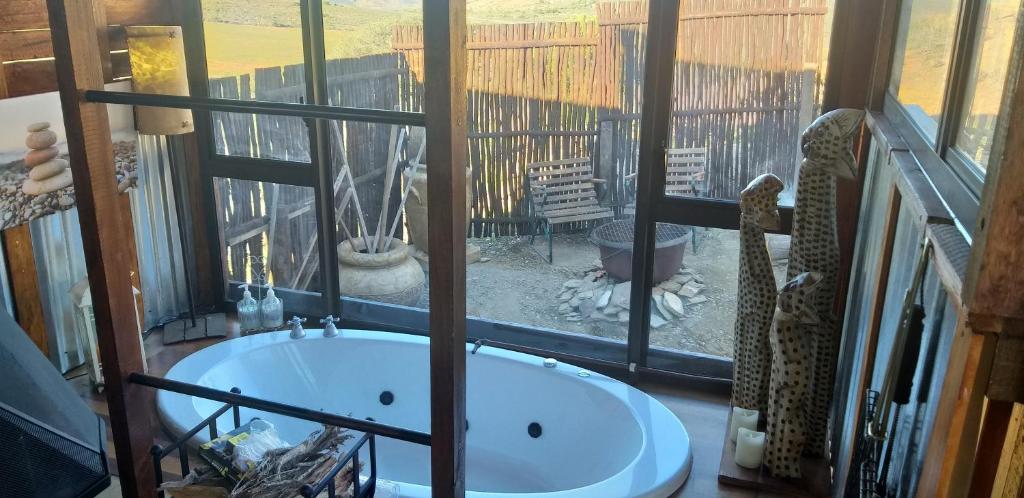 a bath tub in a room with a window at Romantic Cottage in Barrydale