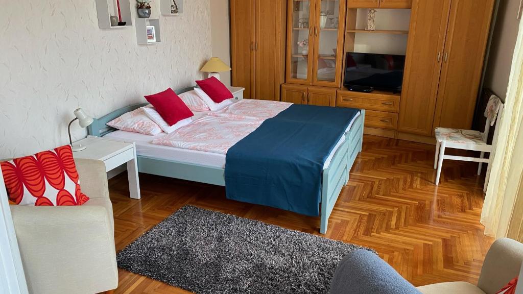 ein Schlafzimmer mit einem Bett, einem TV und einem Sofa in der Unterkunft Balàzs Apartman in Eger