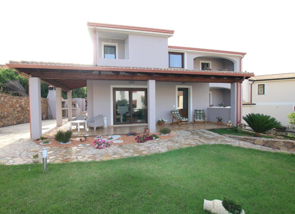 ein großes weißes Haus mit einer Terrasse und einem Hof in der Unterkunft Guest house Ajo' a mulinu in Teulada