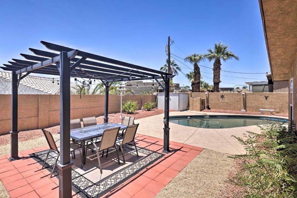 un patio avec une table et des chaises à côté d'une piscine dans l'établissement 3 Mi to Marina Lake Havasu Home with Heated Pool, à Lake Havasu City