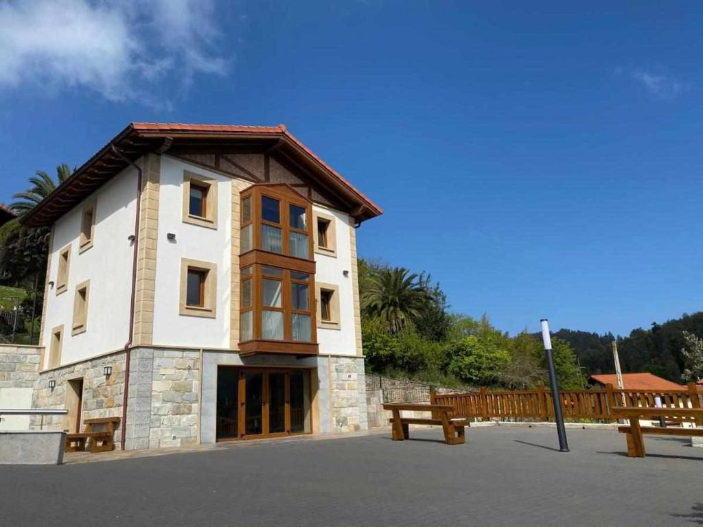 ein Gebäude mit einer Bank davor in der Unterkunft Casa Rural Mugarri in Poveña