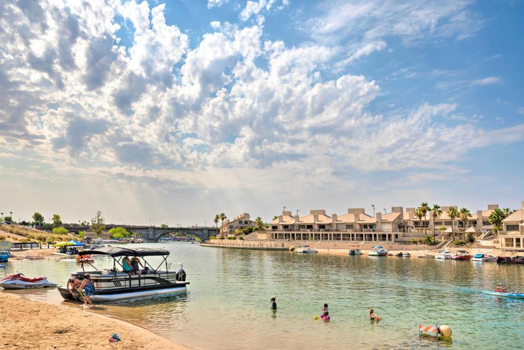 a boat on a river with people in the water at Havasu Condo with View of Lake and London Bridge! in Lake Havasu City