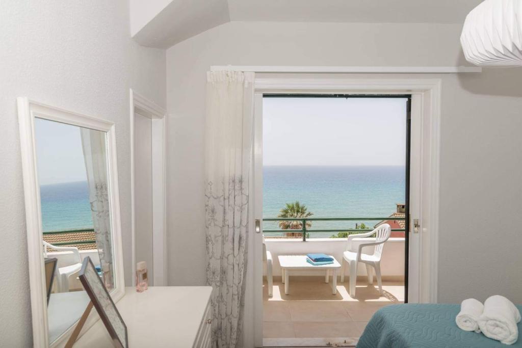 1 dormitorio con balcón con vistas al océano en Aria, Maisonette in Glyfada Beach, en Glyfada