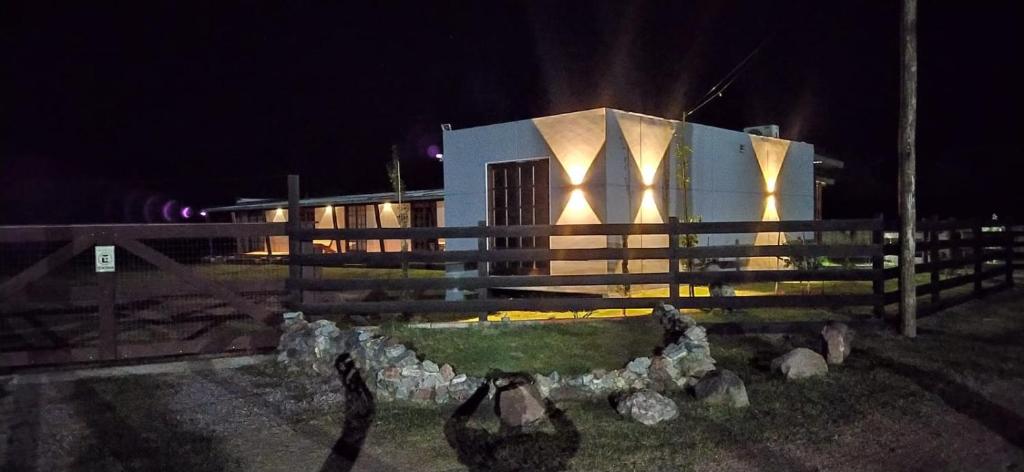 een gebouw met een hek er 's nachts voor bij POSADA ALUC, se reserva solo con seña in Chuy