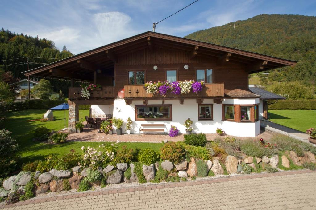 ein Haus mit Garten davor in der Unterkunft Ferienwohnungen Schneider in Kirchdorf in Tirol