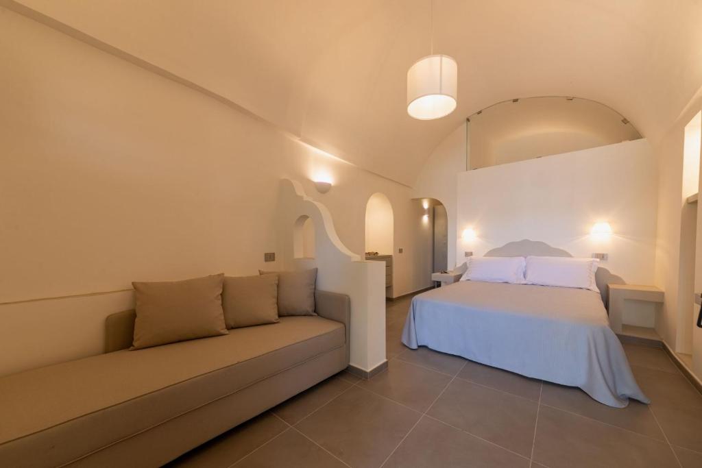 a bedroom with a bed and a couch at Insula Boutique Hotel in Procida