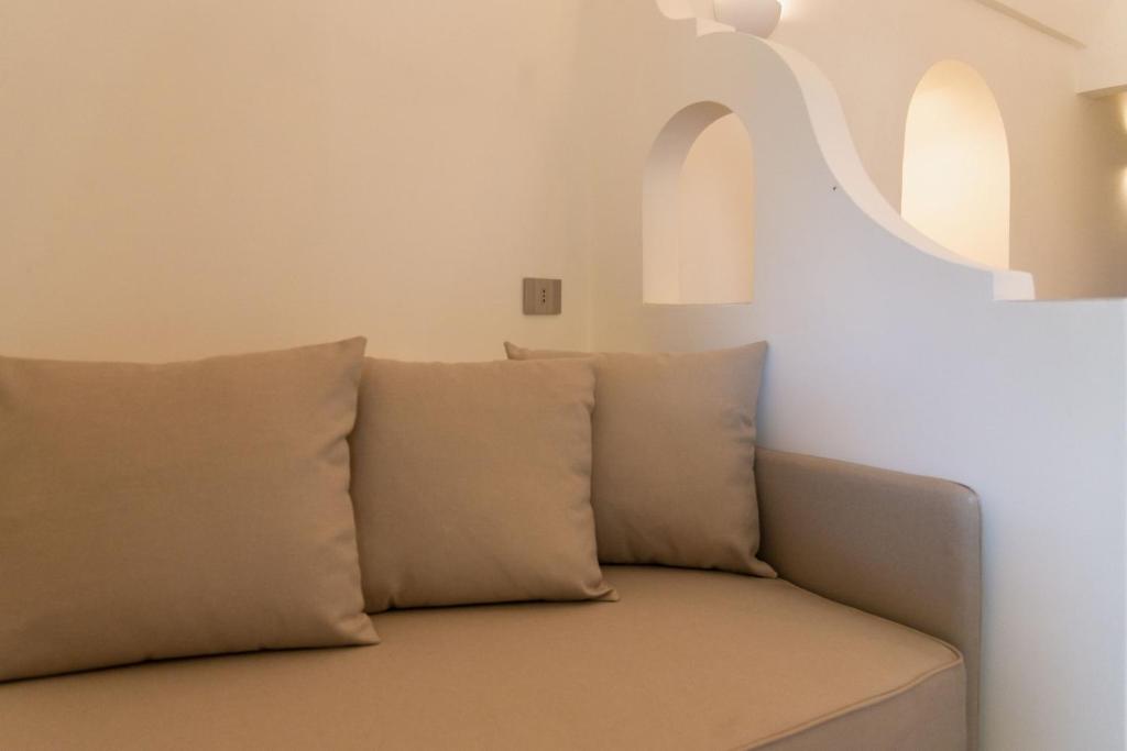 a couch with pillows in a living room at Insula Boutique Hotel in Procida