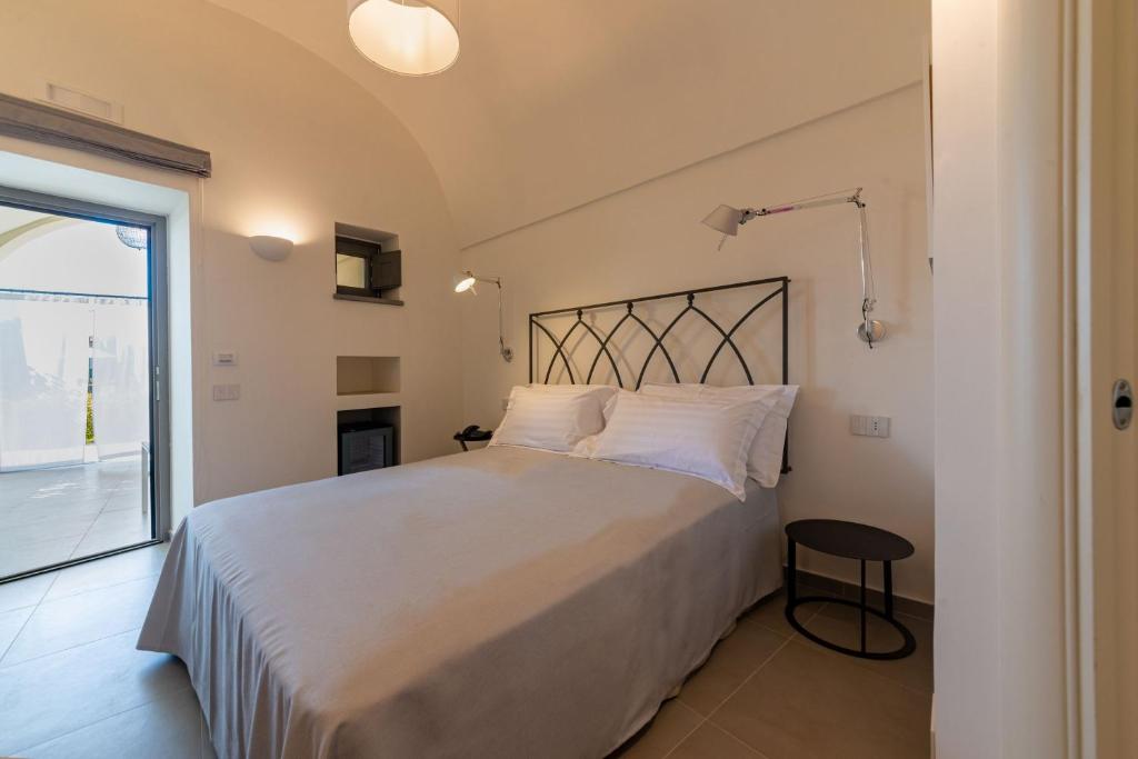 a bedroom with a large bed and a window at Insula Boutique Hotel in Procida