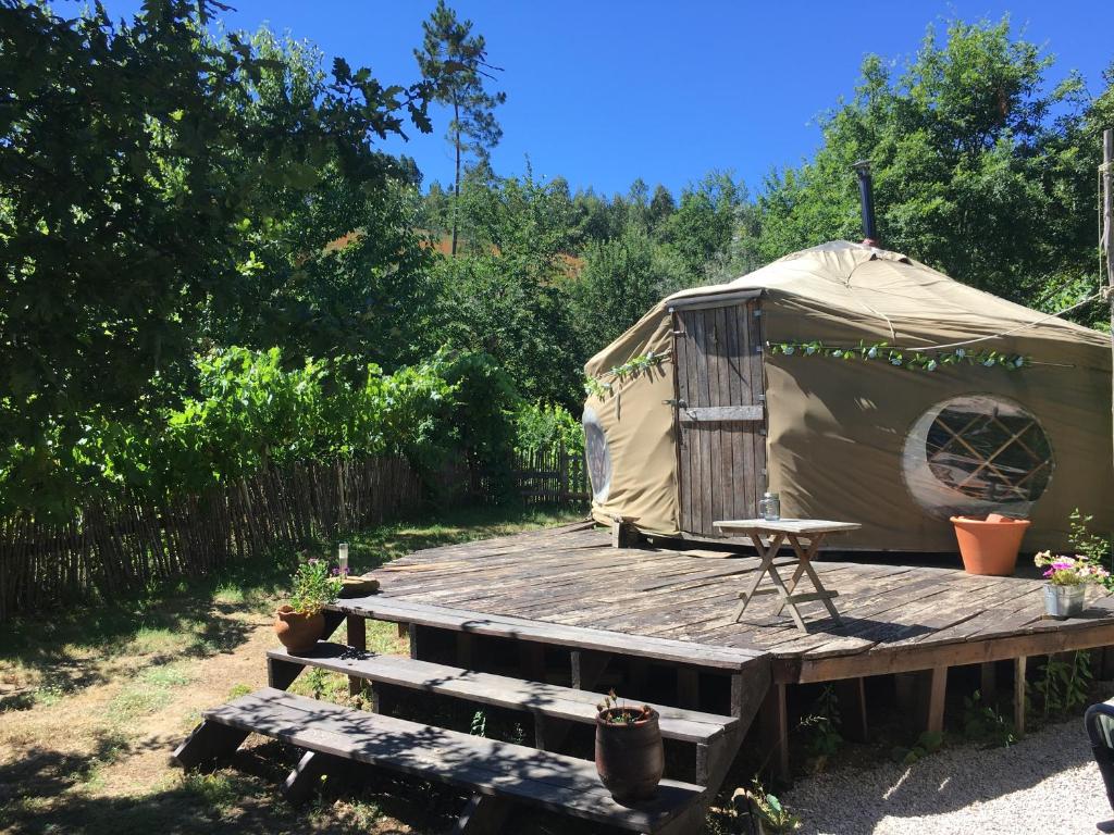 une yourte avec une table sur une terrasse en bois dans l'établissement Star Gazing Luxury Yurt with RIVER VIEWS, off grid eco living, à Vale do Barco