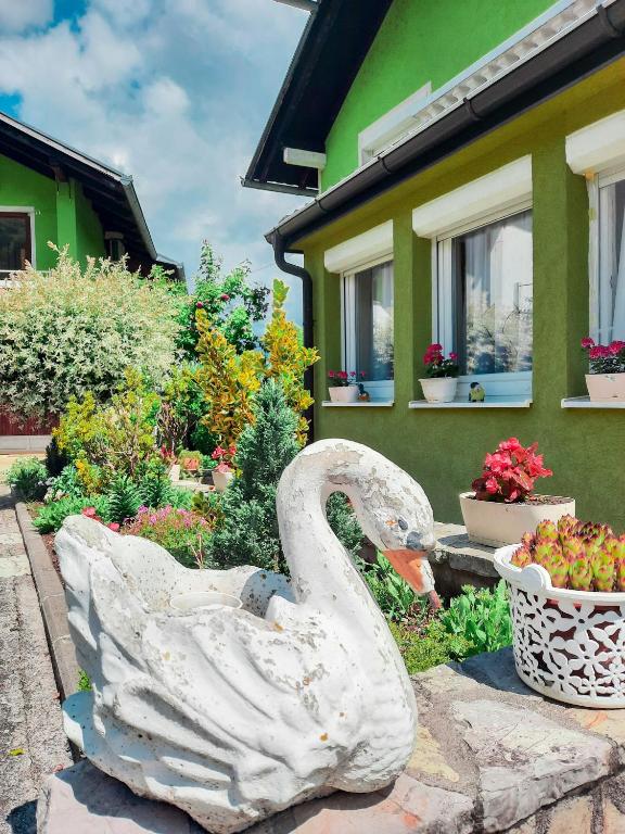 a statue of a swan in front of a house at Holiday Home CASTLE in Bihać