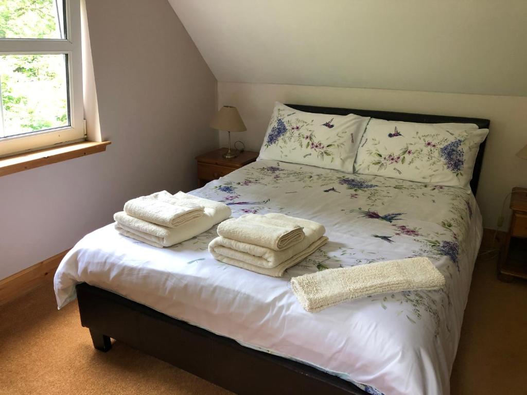 sypialnia z łóżkiem z ręcznikami w obiekcie Foresters Lodge bed and breakfast, near loch ness w mieście Inverfarigaig