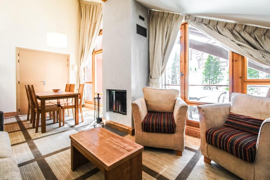 uma sala de estar com um sofá e cadeiras e uma lareira em Charming 6th-floor 2-bedroom apartment with fireplace em Flaine