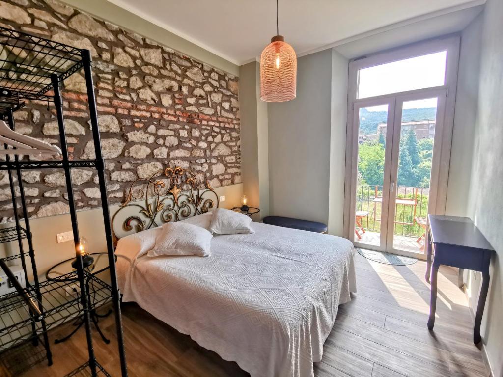 - une chambre avec un lit et un mur en briques dans l'établissement La Luna dei Medici, à Fivizzano