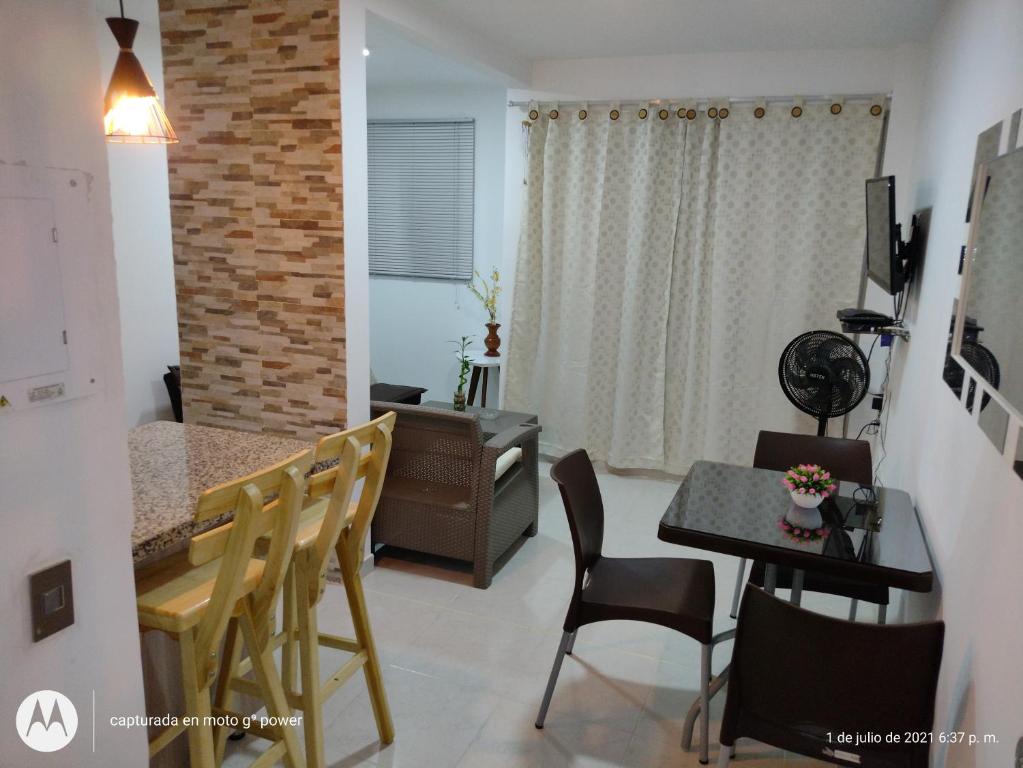 Il comprend une cuisine et un salon avec une table et des chaises. dans l'établissement Hermoso Apartamento Amoblado, à Carthagène des Indes