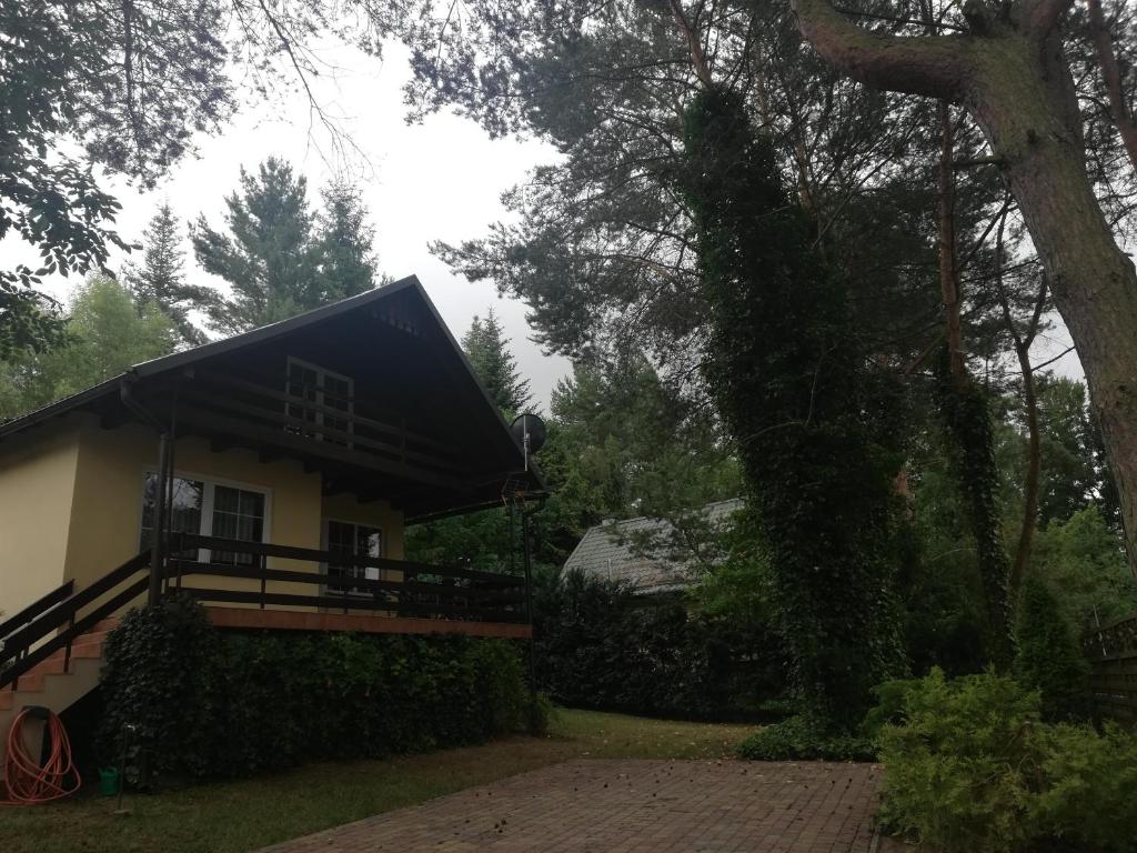 una casa con techo negro y porche en Kaszuby dom nad jeziorem Szczytno Duże, en Dobrzyń