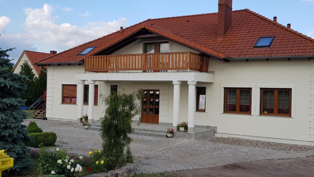 une maison blanche avec un toit rouge dans l'établissement Willa Maria, à Łagów