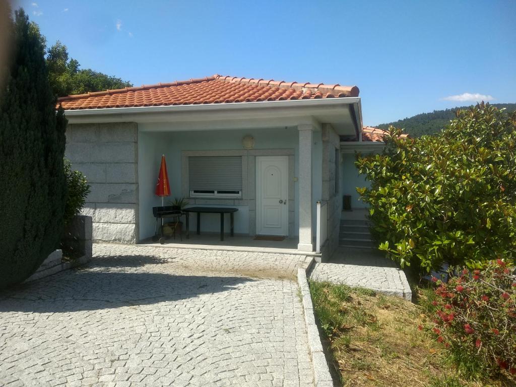 uma pequena casa com uma mesa em frente em Casa do Carvalho em Ribeira de Pena