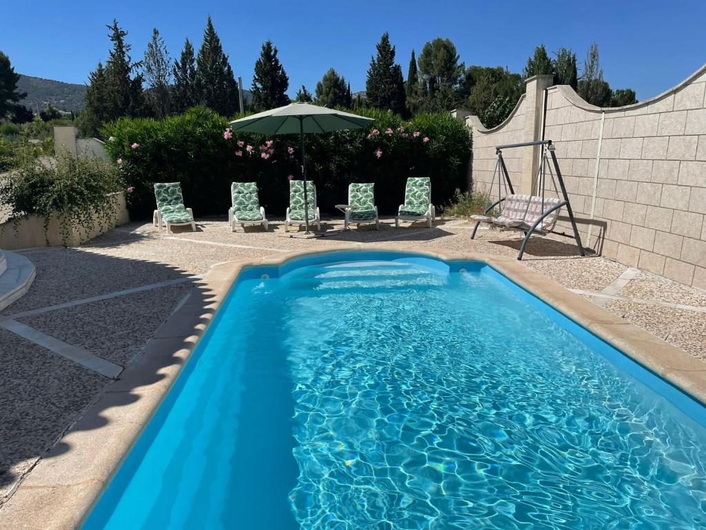 una piscina azul con sillas y sombrilla en Luxury Villa with private pool near Ronda, en Arriate