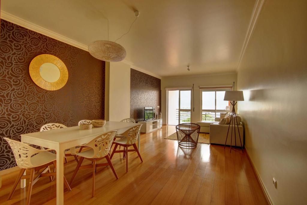 ein Esszimmer und ein Wohnzimmer mit einem Tisch und Stühlen in der Unterkunft Balcony with view, private garage, an elevator in Setúbal