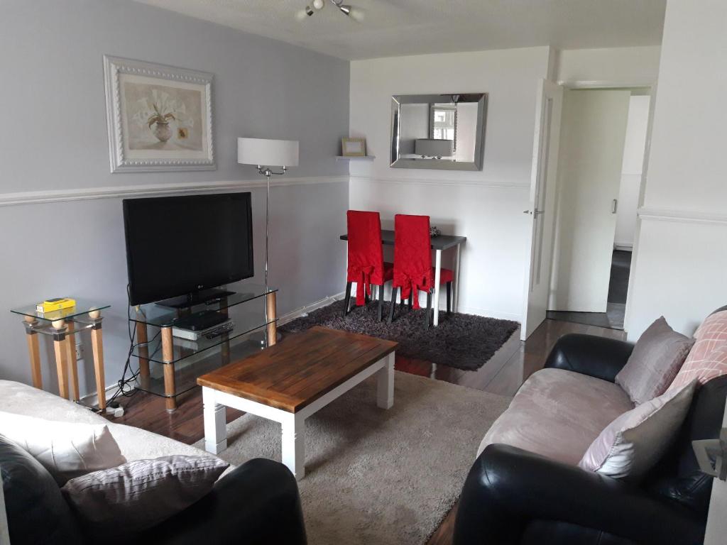 a living room with a couch and a tv at Hardgate Gardens in Glasgow