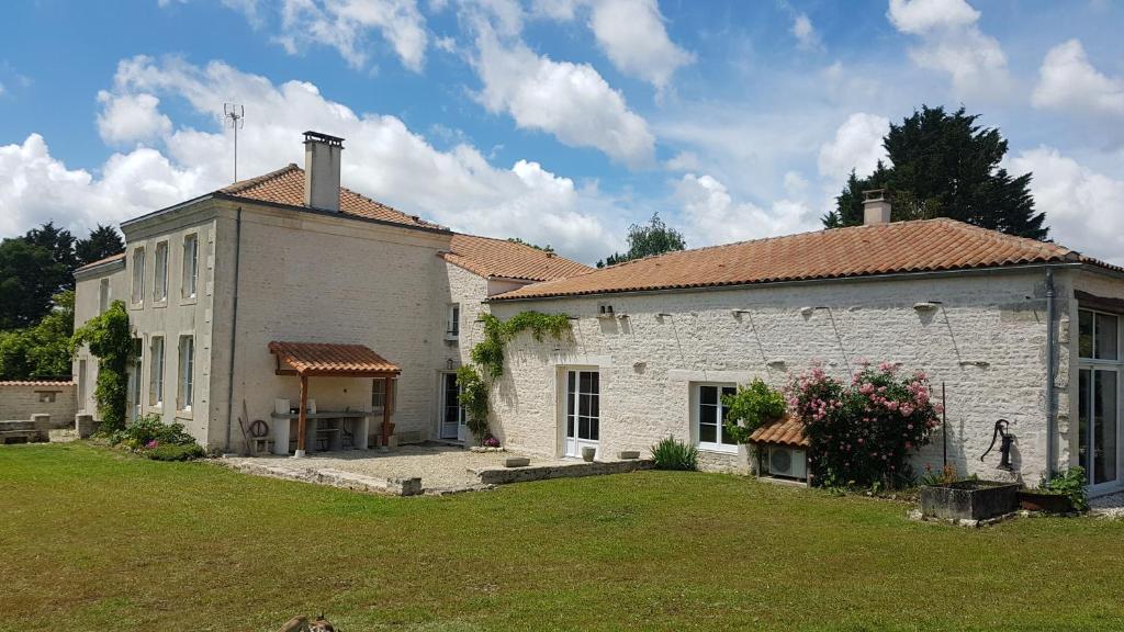 una grande casa in mattoni bianchi con cortile di La Marsaisienne a Marsais