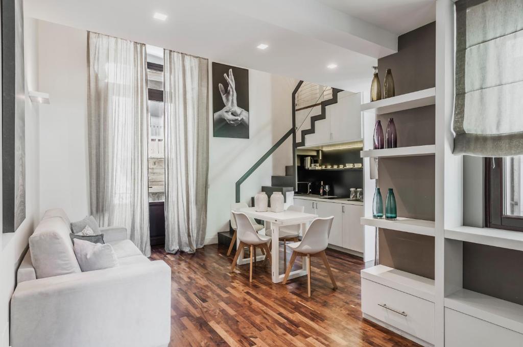 a living room with a white couch and a table at Ferrini Home - Via Monte Sant'Agata in Catania