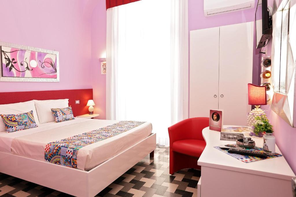 1 dormitorio con 1 cama y 1 silla roja en B&B Antonello da Messina en Messina