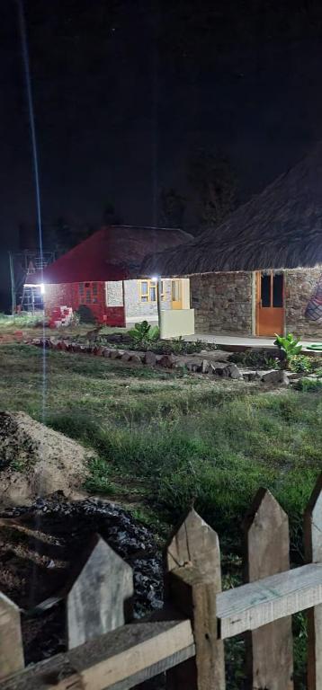 a house with a fence in front of it at night at Le Tai Village Resort near Solio Game Reserve in Mweiga
