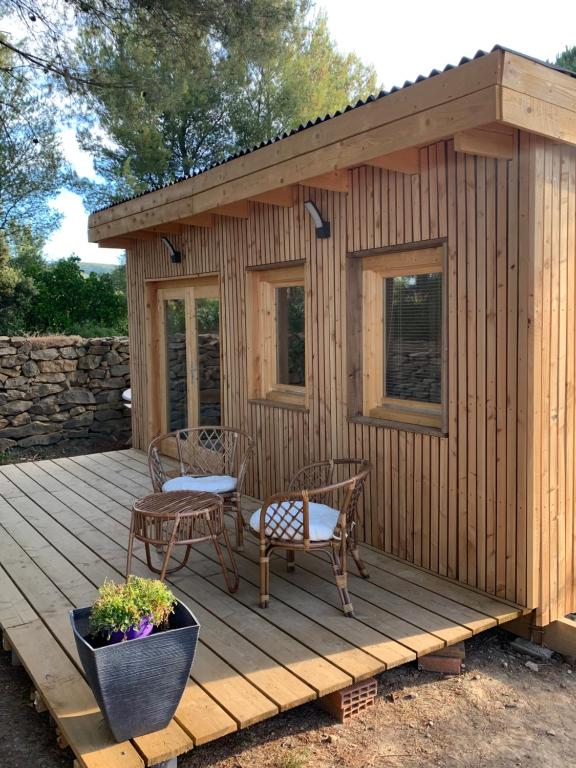 een hut met twee stoelen en een tafel op een terras bij Chambre privée avec accès piscine in Laouque