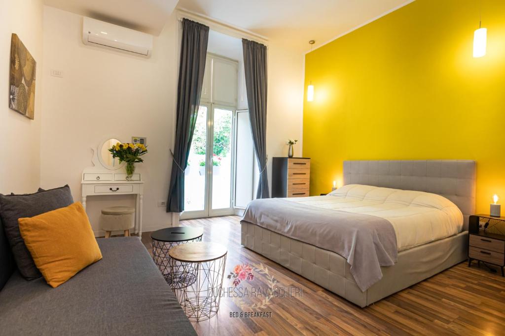 um quarto com uma cama e uma parede amarela em Duchessa Ravaschieri bed and breakfast em Nápoles