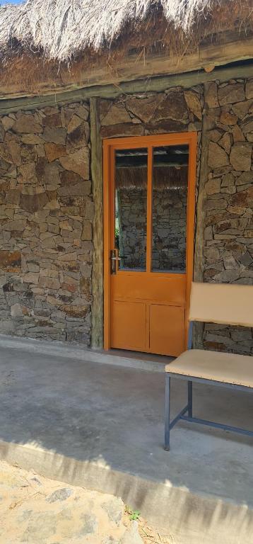 a door of a stone building with a bench in front at Le Tai Village Resort near Solio Game Reserve in Mweiga