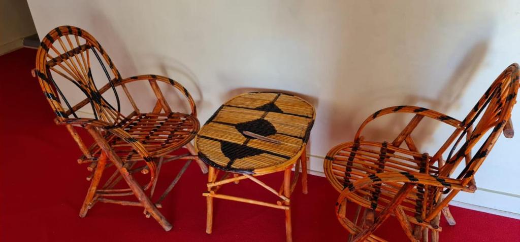 three chairs and a table in a room at Le Tai Village Resort near Solio Game Reserve in Mweiga