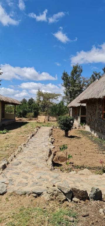 a dirt road next to a house and a building at Le Tai Village Resort near Solio Game Reserve in Mweiga