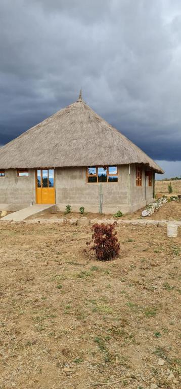 a small house with a thatheasternheasternheasternheastern at Le Tai Village Resort near Solio Game Reserve in Mweiga