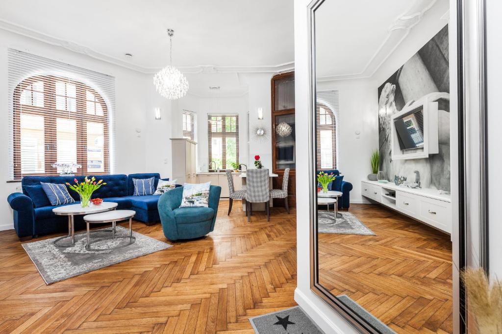 a living room with a blue couch and a table at Apartamenty4you - Apartamenty Atlantic in Sopot