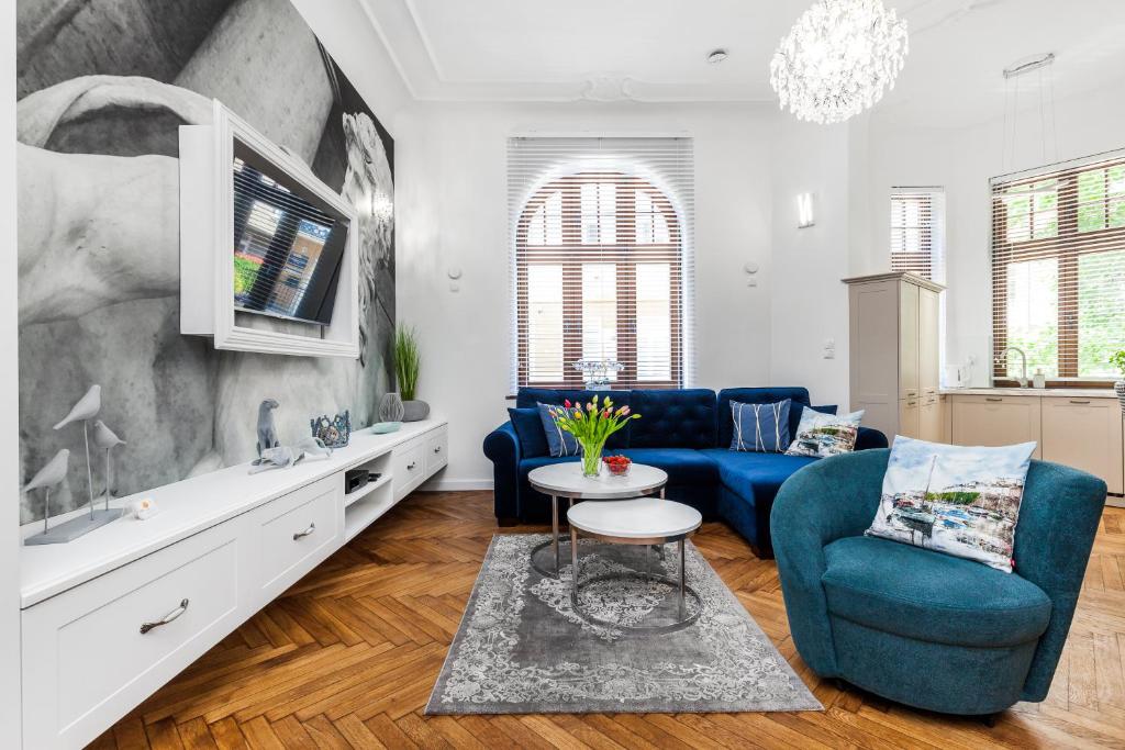 salon z niebieską kanapą i stołem w obiekcie Apartamenty4you - Apartamenty Atlantic w mieście Sopot